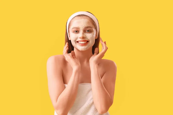 黄色の背景に適用ターメリックマスクを持つ若い女性 — ストック写真