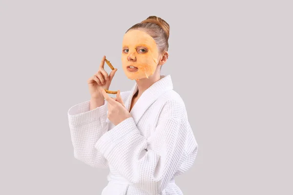 Young Woman Bathrobe Turmeric Sheet Mask Roots Grey Background — Stock Photo, Image