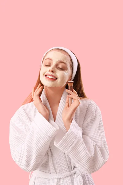 Jonge Vrouw Badjas Met Toegepast Kurkuma Masker Borstel Roze Achtergrond — Stockfoto
