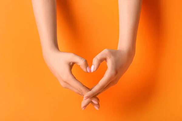 Kobieta Robi Serce Rąk Pomarańczowym Tle — Zdjęcie stockowe