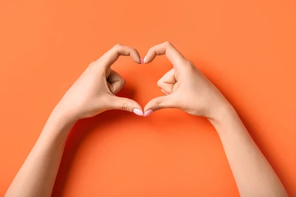Kvinna Gör Hjärta Med Händerna Orange Bakgrund — Stockfoto