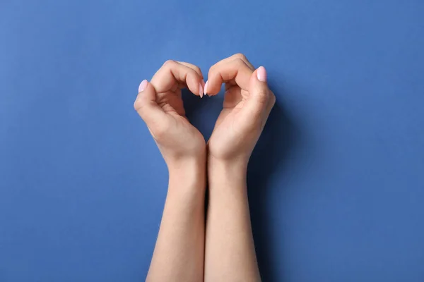 Kobieta Robi Serce Rękami Niebieskim Tle — Zdjęcie stockowe