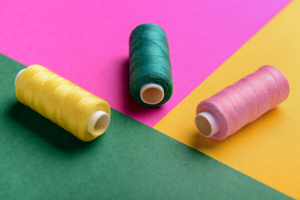 Set of thread spools on color background