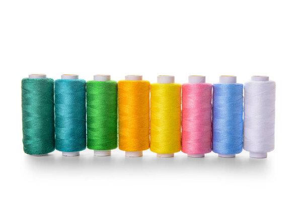 Set of colorful thread spools on white background