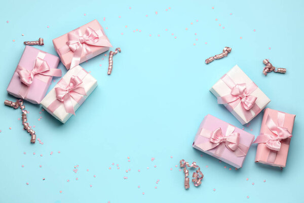Frame made of gift boxes with bows, confetti and serpentine on blue background