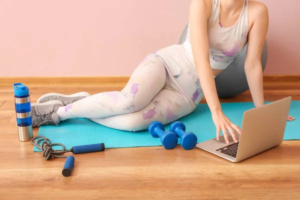 健身房使用笔记本电脑的带运动器械的妇女 — 图库照片