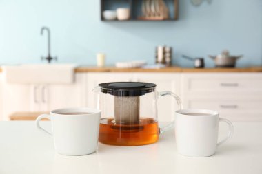 Çaydanlık ve fincanlar mutfaktaki masada.