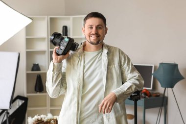 Stüdyoda profesyonel kamerası olan yakışıklı bir fotoğrafçı.