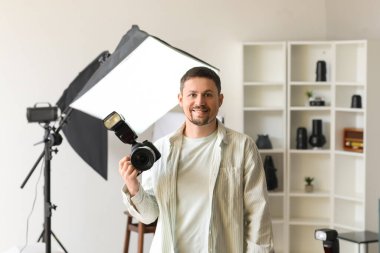 Stüdyoda profesyonel kamerası olan yakışıklı bir fotoğrafçı.