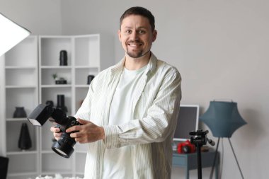 Stüdyoda profesyonel kamerası olan yakışıklı bir fotoğrafçı.
