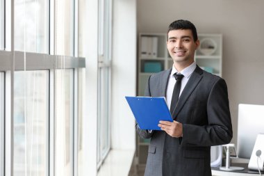 Young accountant with document in office