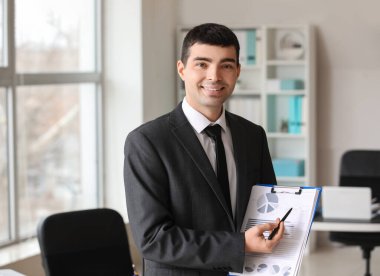 Young accountant with document in office