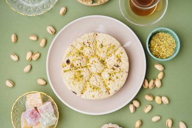 Fıstıklı Tahini halva tabağı ve yeşil arka planda Türk lokumu.