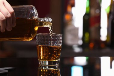 Bardaki masada bardaktan cama rom döken kadın.