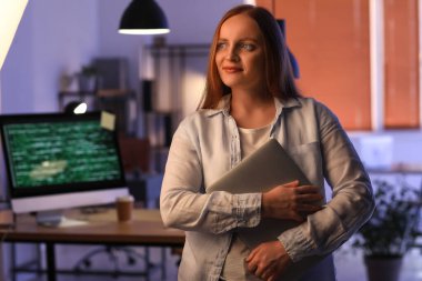 Geceleri dizüstü bilgisayarı olan kadın programcı.