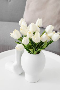 Güzel lale çiçekleri ve seramik eli olan bir vazo, yakın plan.