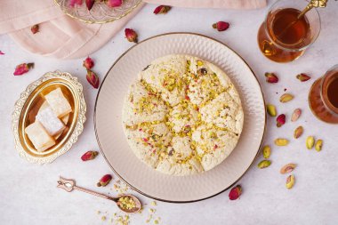 Lezzetli Tahini halva tabağı ve arka planda bir fincan çay.