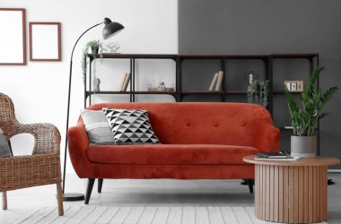 Modern oturma odasının içinde rahat bir kanepe ve sehpanın üzerinde çiçek var.