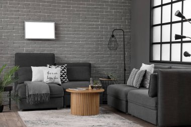 Kahve masasında rahat koltukları ve floraryumu olan modern oturma odasının içinde.