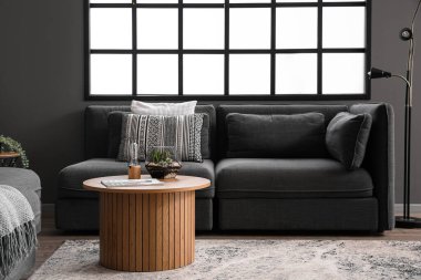 Modern oturma odasında floraryum, lamba ve dergi olan kahve masası.