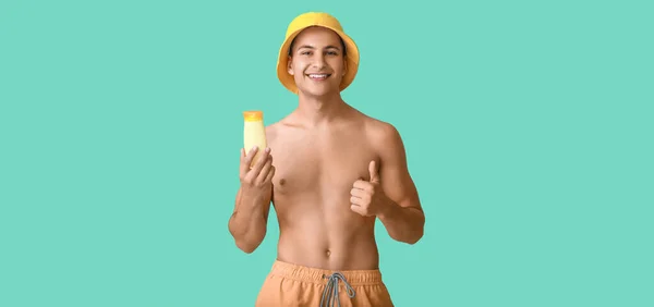 Happy Young Man Sun Protection Cream Showing Thumb Turquoise Background — Stock Photo, Image