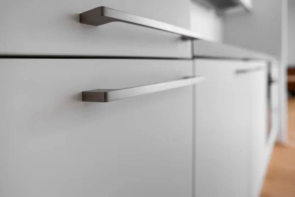 White counter with handles in modern kitchen, closeup
