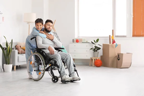 車椅子の少年と父親が家で抱き合って — ストック写真