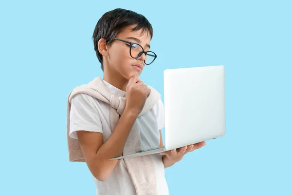 Thoughtful Little Boy Eyeglasses Using Laptop Blue Background — Stock Photo, Image