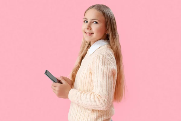 ピンクの背景に携帯電話を使用して女の子 — ストック写真
