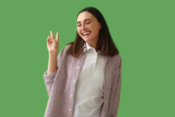 Ευτυχισμένη Νεαρή Γυναίκα Δείχνει Χειρονομία Νίκης Στο Πράσινο Φόντο — Φωτογραφία Αρχείου