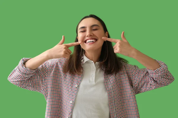 Yeşil Arka Planda Dişlerini Gösteren Genç Bir Kadın — Stok fotoğraf