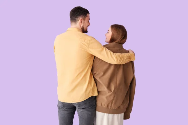 Young Man Hugging Wife His Jacket Lilac Background Back View — Stock Photo, Image