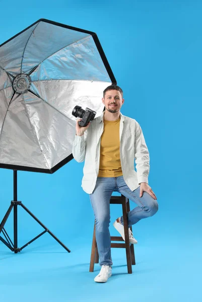 Fotógrafo Masculino Com Câmera Profissional Sentado Fundo Azul — Fotografia de Stock