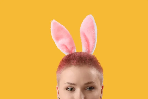 黄色の背景にウサギの耳を持つ若い女性 クローズアップ — ストック写真