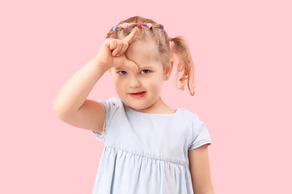 可爱的小女孩在粉红的背景上表现出失败的姿态 — 图库照片