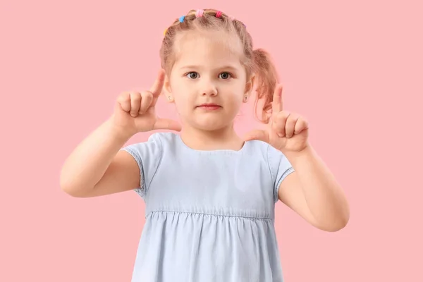 Zabawna Dziewczynka Pokazuje Gest Frajera Różowym Tle — Zdjęcie stockowe