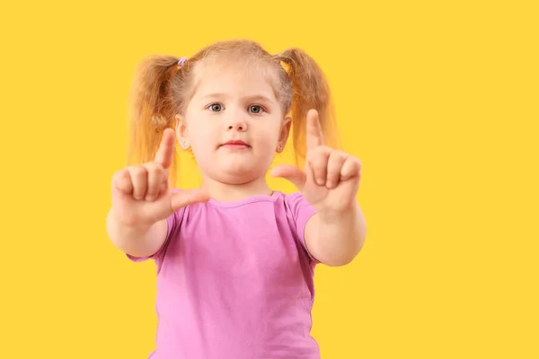 Zabawna Dziewczynka Pokazuje Gest Frajera Żółtym Tle — Zdjęcie stockowe