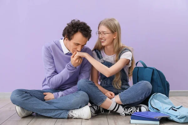 十几岁的男孩在紫丁香墙边亲吻他女朋友的手 — 图库照片