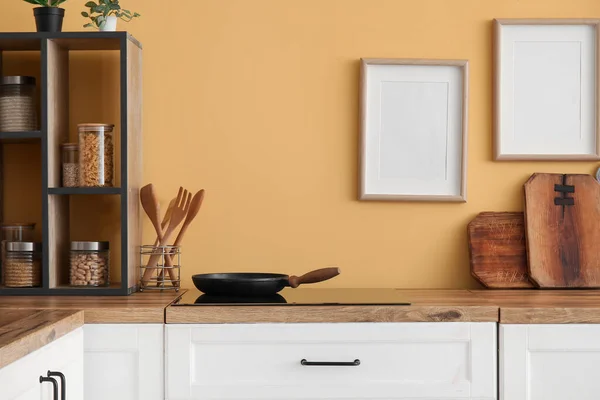 黄色の壁の近くにフライパン ストーブ キッチン用品とのカウンター — ストック写真