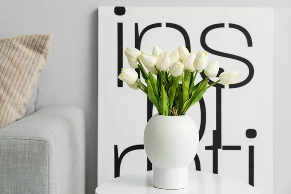 灰色の壁の近くのテーブルとポスターに美しいチューリップの花の花瓶 — ストック写真