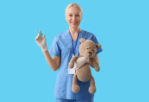 Medico Maturo Con Siringa Orso Giocattolo Sfondo Blu — Foto Stock