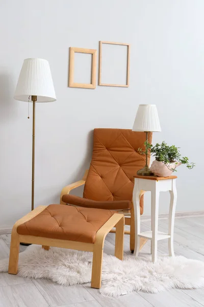 靠墙的桌子上有舒适的褐色扶手椅 有脚凳 灯具和室内盆栽 — 图库照片