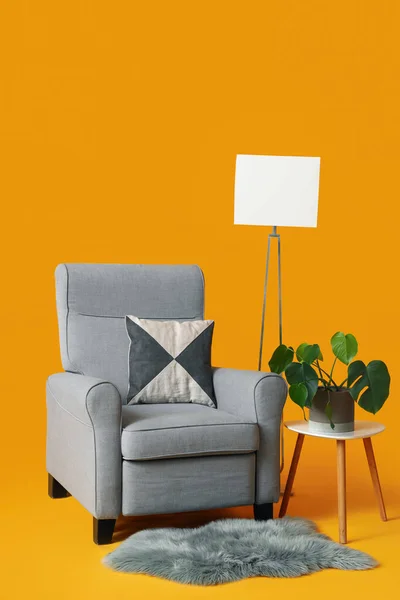 Przytulny Szary Fotel Lampa Stół Rośliną Domową Pomarańczowym Tle — Zdjęcie stockowe