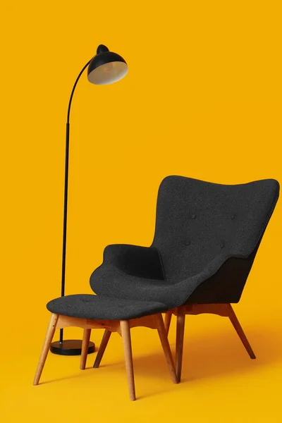 舒适的黑色扶手椅 脚凳和橙色背景灯 — 图库照片