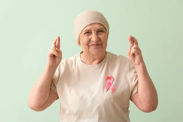 Senior Woman Chemotherapy Pink Ribbon Crossing Fingers Green Background Breast — Stock Photo, Image