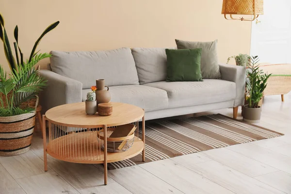 明亮客厅的内部 有舒适的灰色沙发 咖啡桌和室内植物 — 图库照片