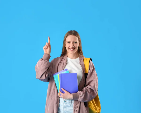Studentin Mit Textbüchern Die Auf Etwas Auf Blauem Hintergrund Zeigen — Stockfoto