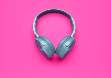 Pembe arka planda modern mavi kulaklıklar