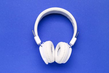 Mavi arka plan üzerinde modern beyaz kulaklık