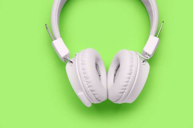 Yeşil arka planda modern beyaz kulaklıklar